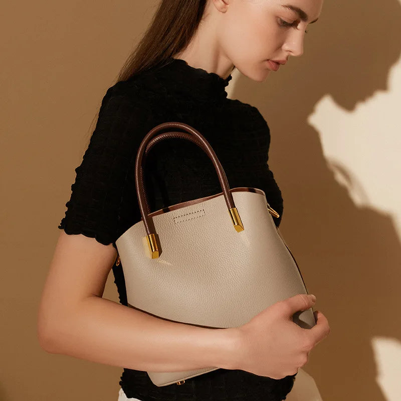 Primavera y verano 2025, bolso tipo cubo de cuero de nicho, bolso extranjero versátil para mujer, bolso cruzado informal de alta gama, bolso de piel de vaca
